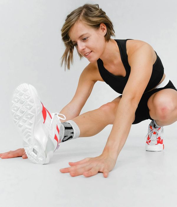 Woman in a dynamic yoga pose on a mat, demonstrating strength and flexibility.